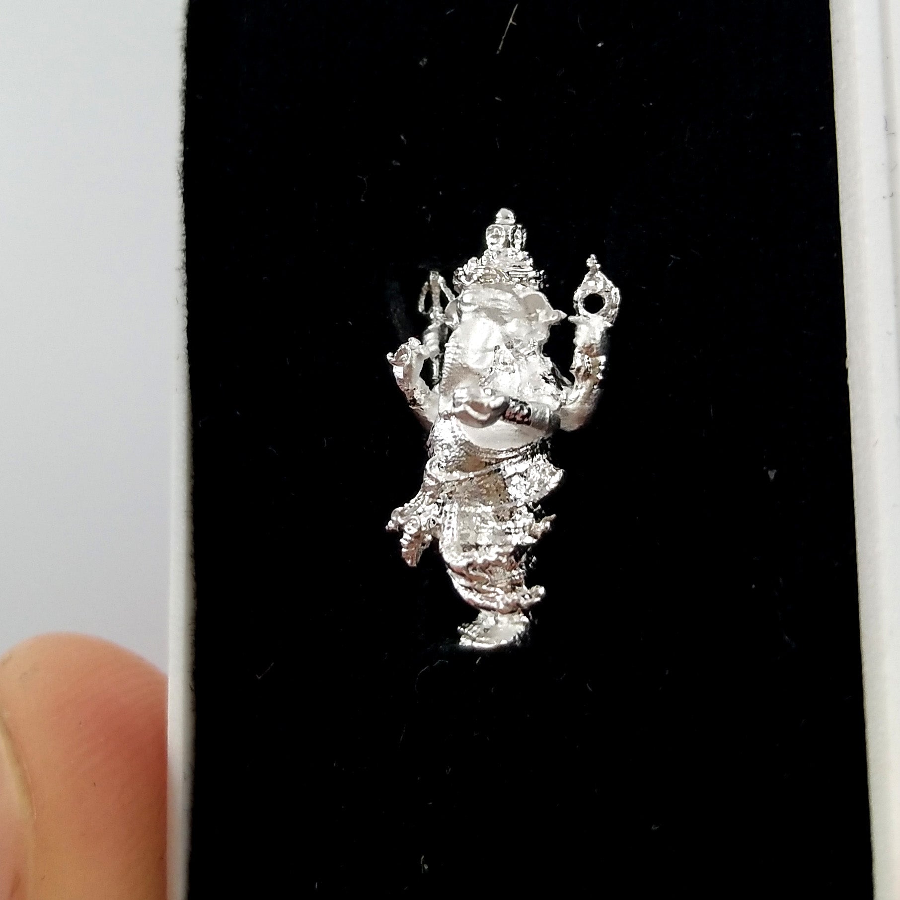 Silver Ganesha amulet for success displayed in a velvet box for home decoration and spiritual blessings