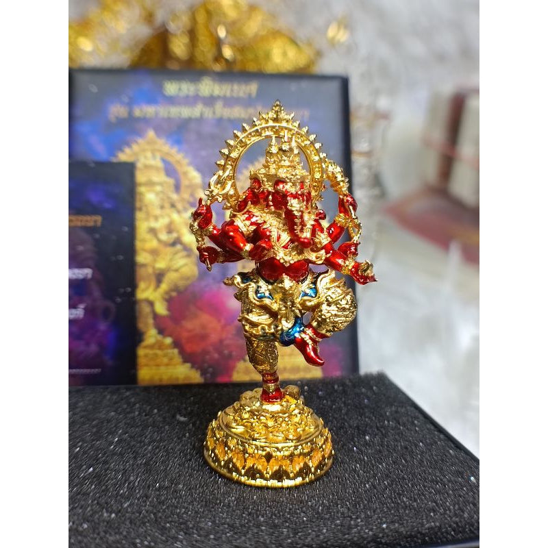 Gold and red Ganesha success fulfillment amulet statue with intricate detailing on a black base