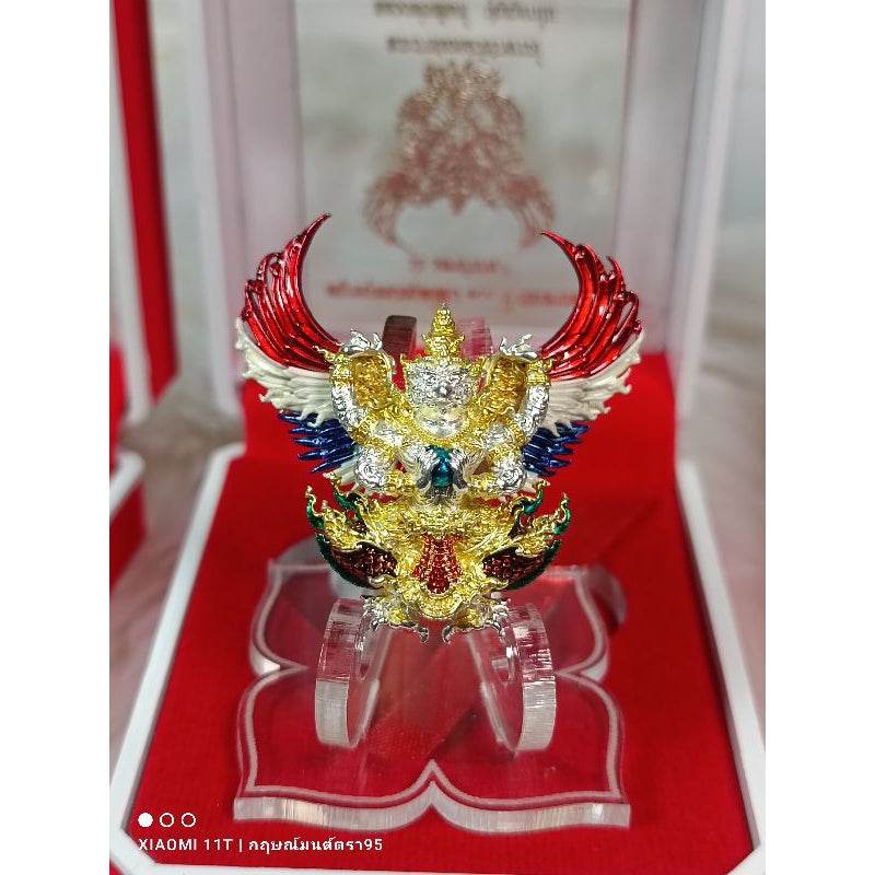 Thai Blessing Co Garuda amulet from Thailand with detailed colorful wings and gold accents in display case
