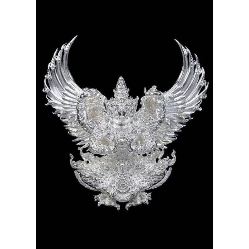 Silver Garuda amulet from Thailand with detailed wings and intricate design on black background