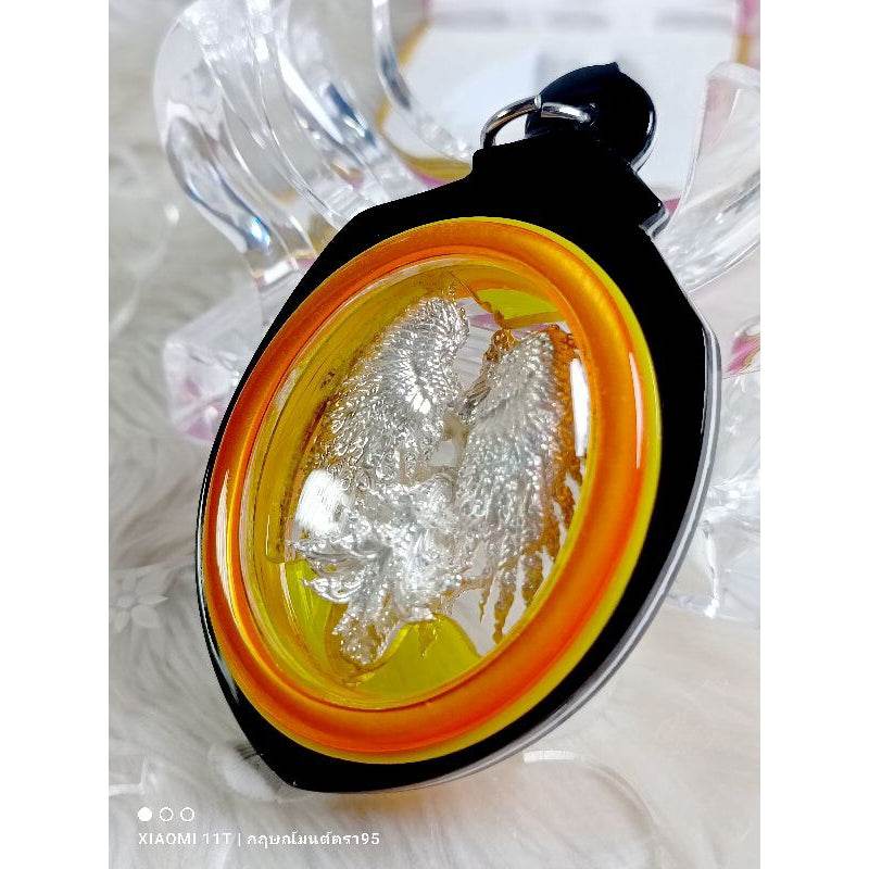 Garuda Parameswara amulet with silver figure encased in yellow and orange round frame pendant