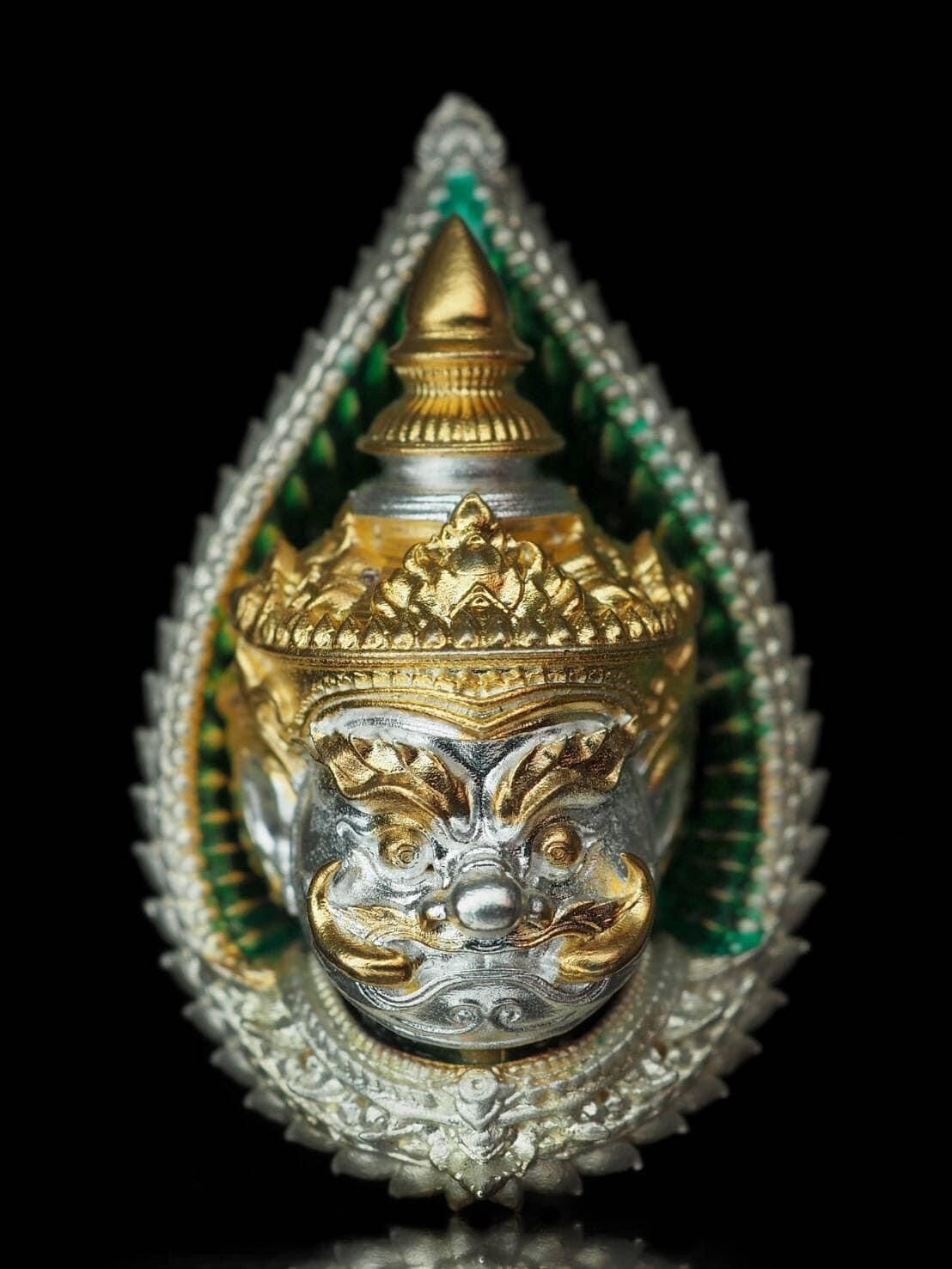 Close-up of a giant guardian amulet gift set with intricate gold and silver detailing and green background