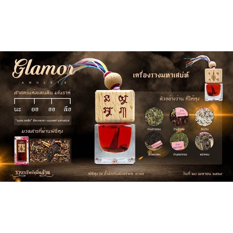 Thai charm oil for prosperity red bottle with wooden carved stopper and colorful tassel displayed with herbs