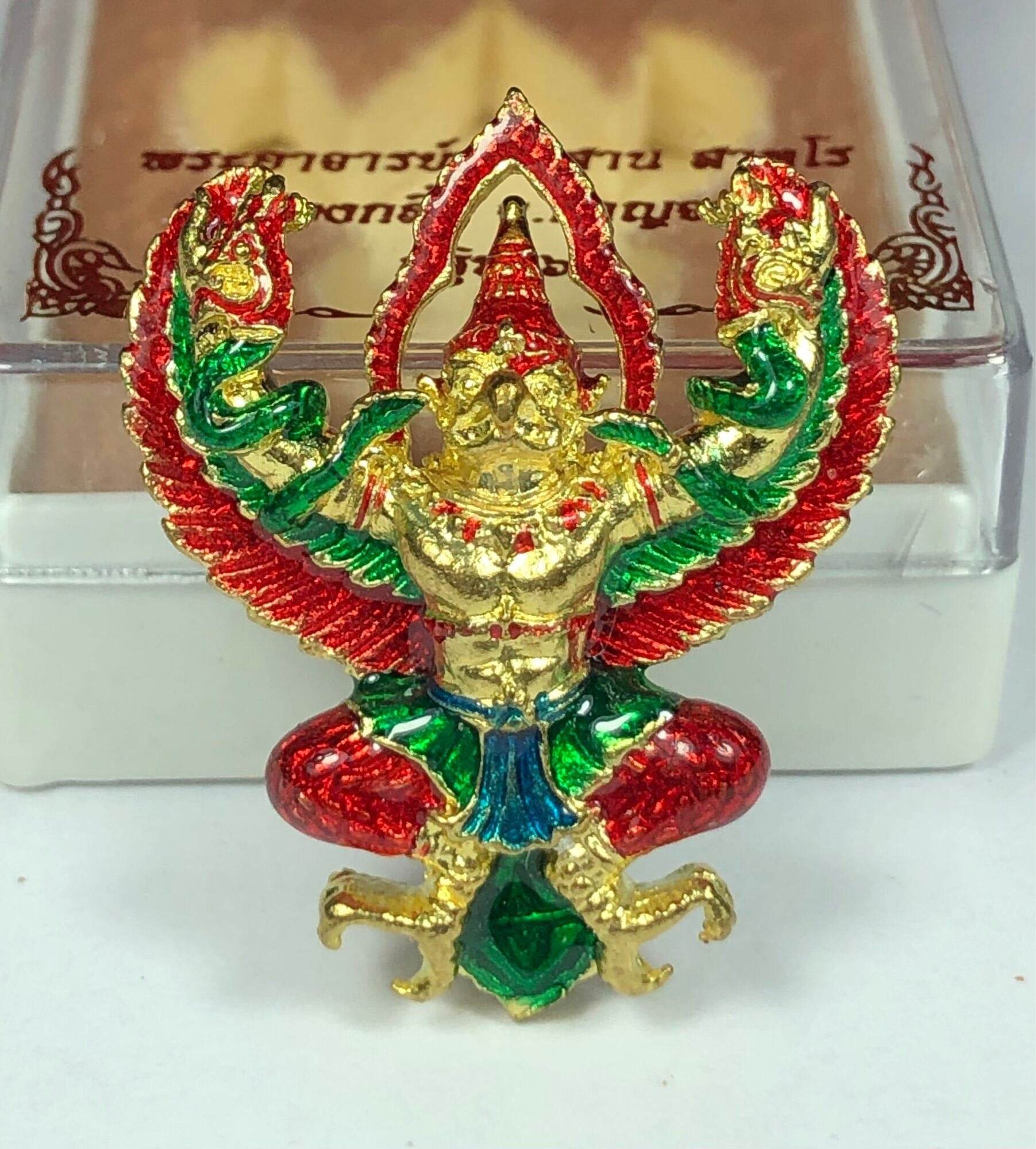 Golden Garuda lucky charm figurine with red green and blue enamel details on display
