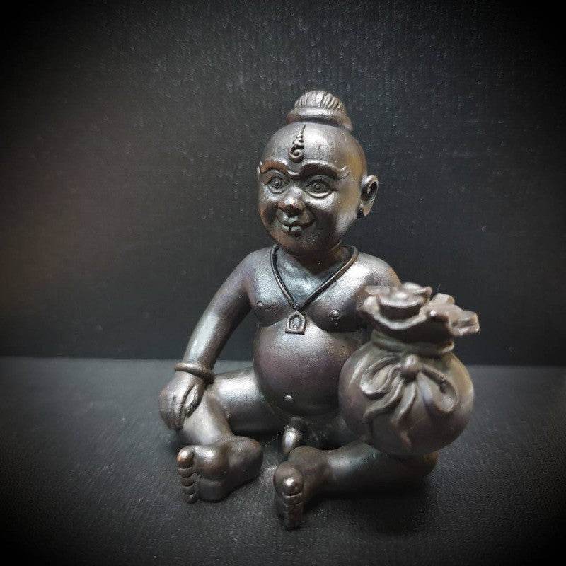 Guardian boy wealth figurine seated with a bag of coins, symbolizing prosperity and fortune