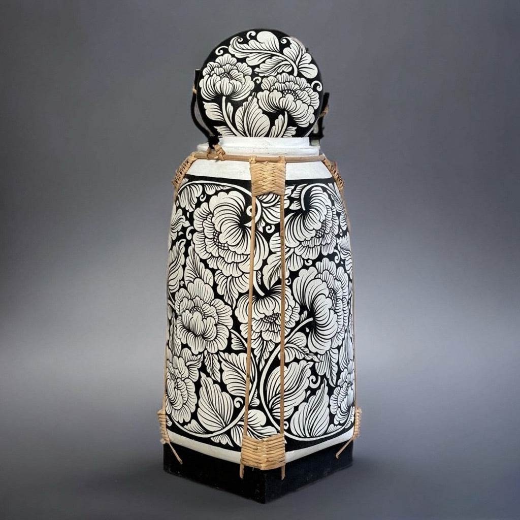 Handmade Thai bamboo rice basket with intricate black and white floral design for food storage