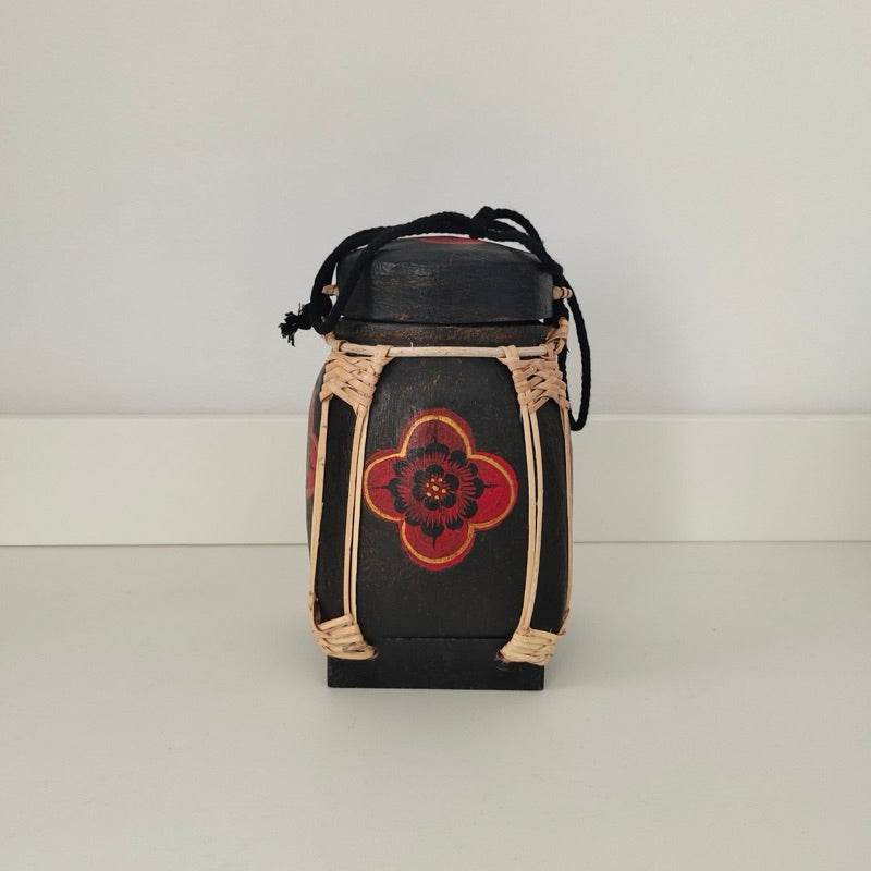 Handmade Thai bamboo rice box with black and red floral design and woven details