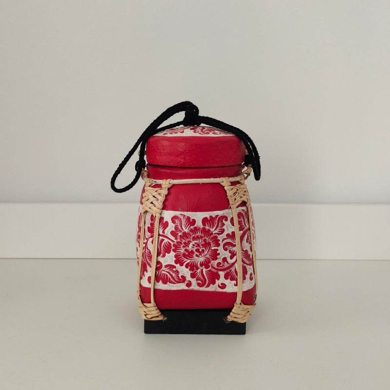 Handmade Thai bamboo rice box with red floral design and black carrying strap from One-Sake.com
