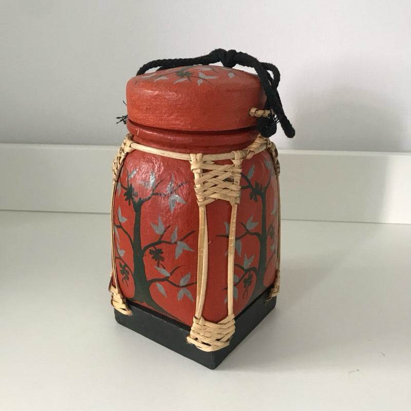 Handmade Thai bamboo rice box with red painted floral design and black base from One-Sake.com