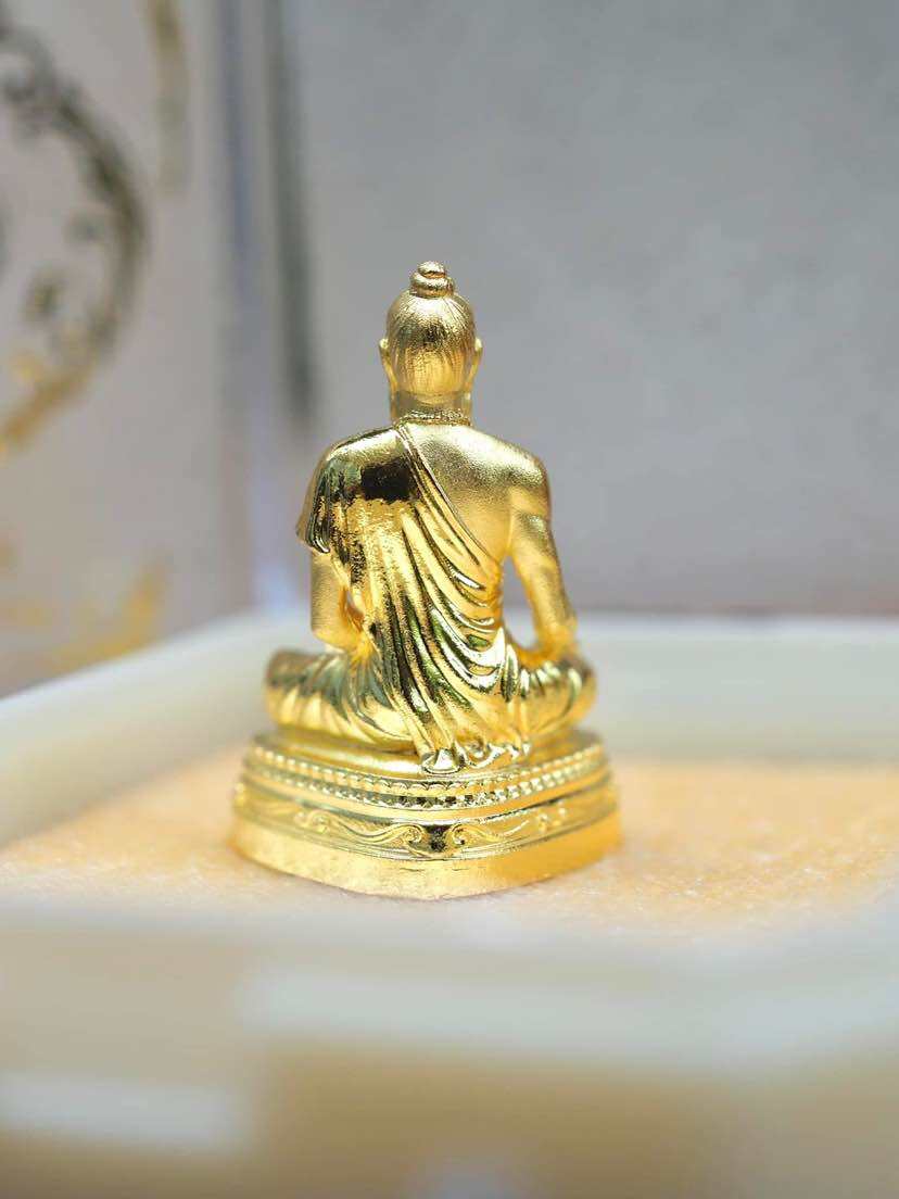 Golden Jivaka Komarabhacca amulet for health displayed in a box, symbolizing wellness and prosperity
