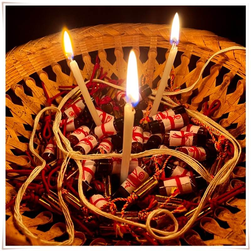 Basket with Khmer attraction oil for love and luck, candles, and traditional offerings for spiritual rituals