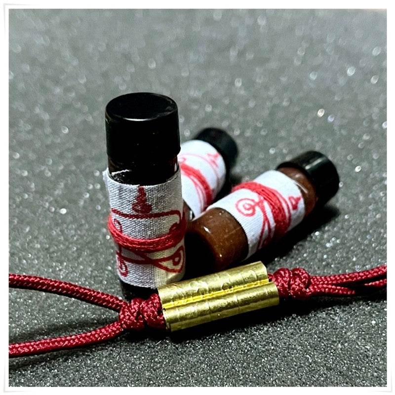 Khmer attraction oil for love and luck in small bottles with decorative wrapping from Thai Blessing Co