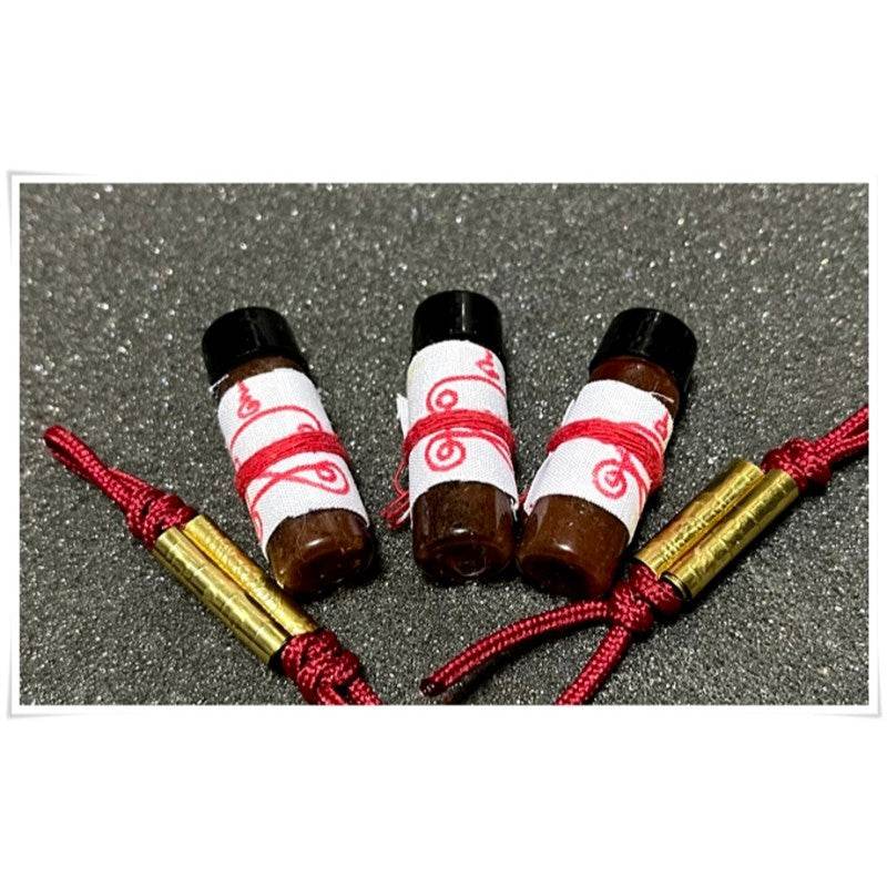 Three bottles of Khmer attraction oil for love and luck with decorative packaging for spiritual practices