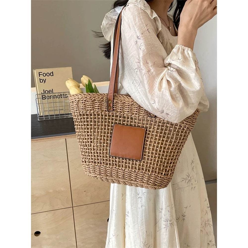 Korean style handwoven basket bag with leather straps carried by woman in white dress