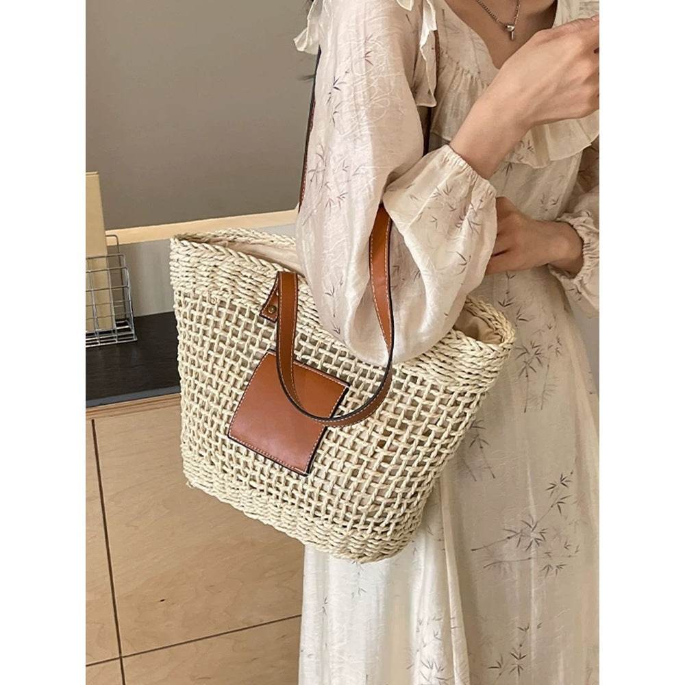 Korean style handwoven basket bag with brown leather straps worn over shoulder by woman in floral dress