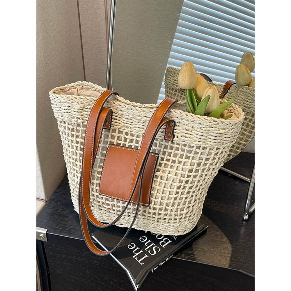Korean style handwoven basket bag with brown leather straps and pocket placed on black table with flowers inside