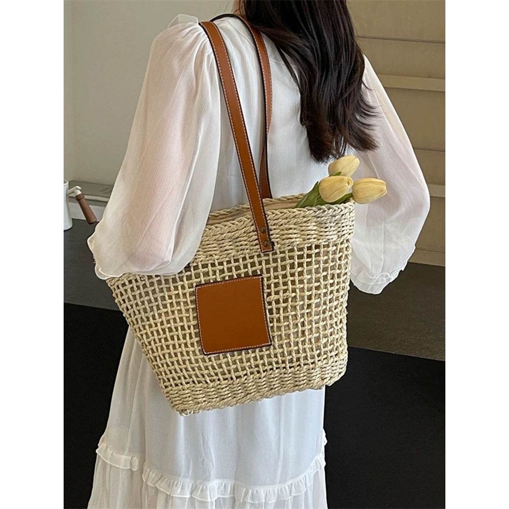 Korean style handwoven basket bag with leather straps and patch carried by woman in white dress