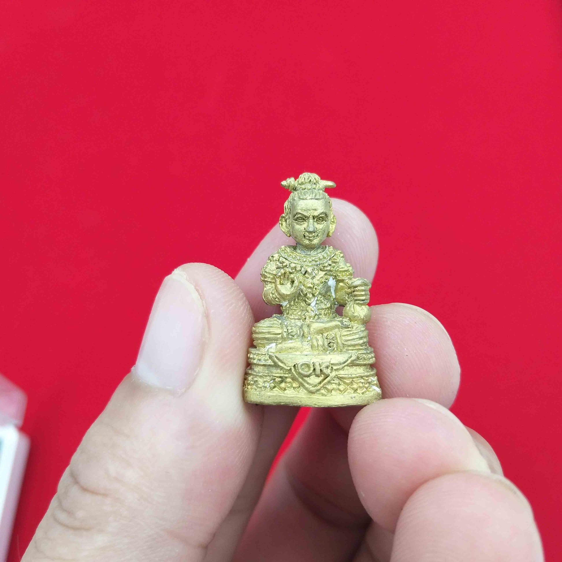 Handheld Kuman Thong amulet for prosperity in gold color, designed for personal blessings and good fortune