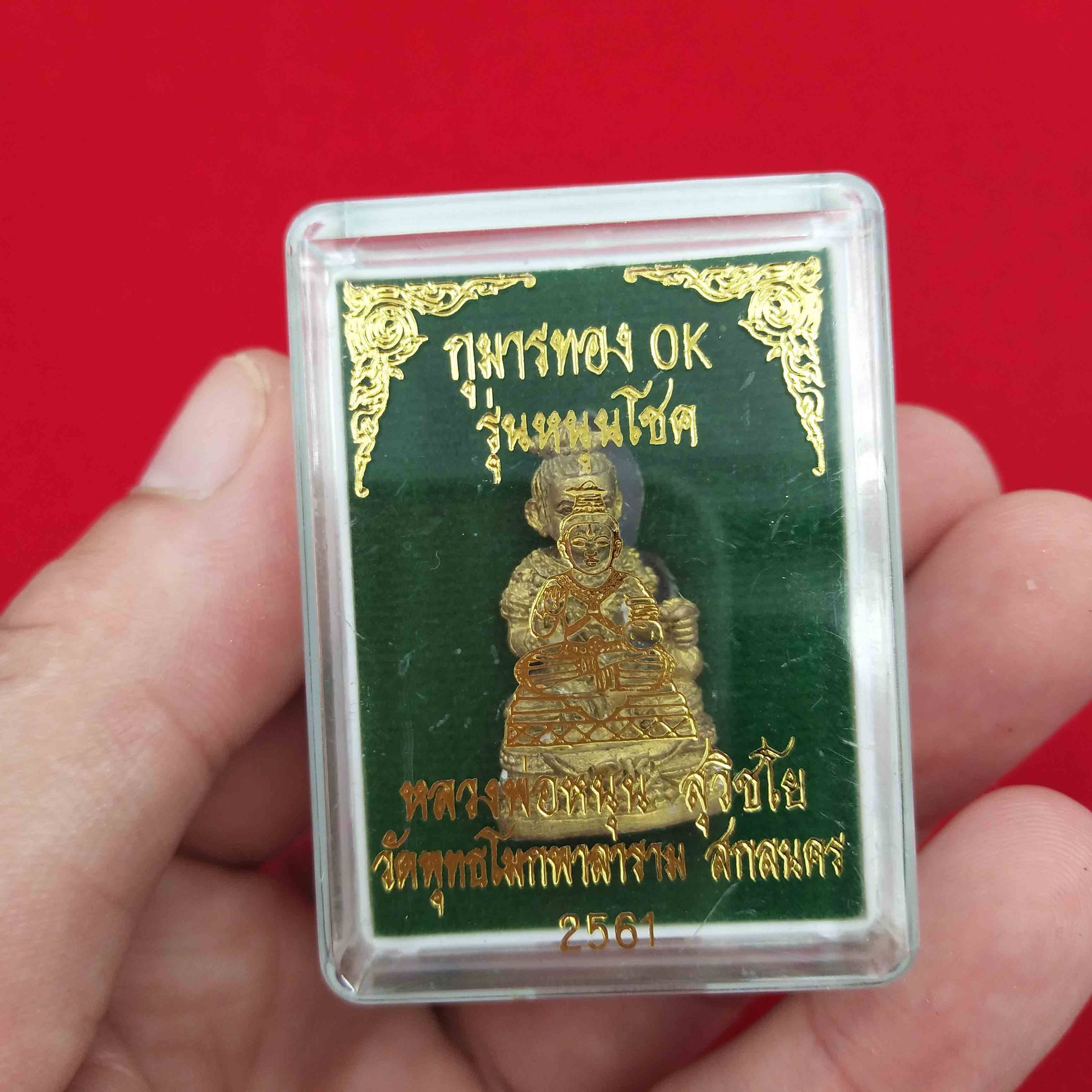 Kuman Thong amulet for prosperity in a protective case, showcasing its detailed design