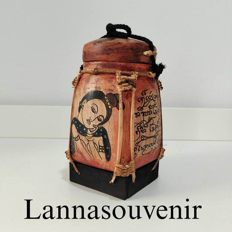 Lanna bamboo blessing box with traditional Thai painting and script on wooden surface