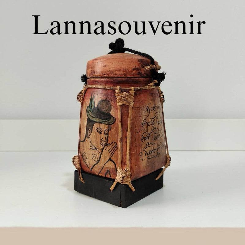 Lanna bamboo blessing box with traditional Lanna artwork and script on wooden surface