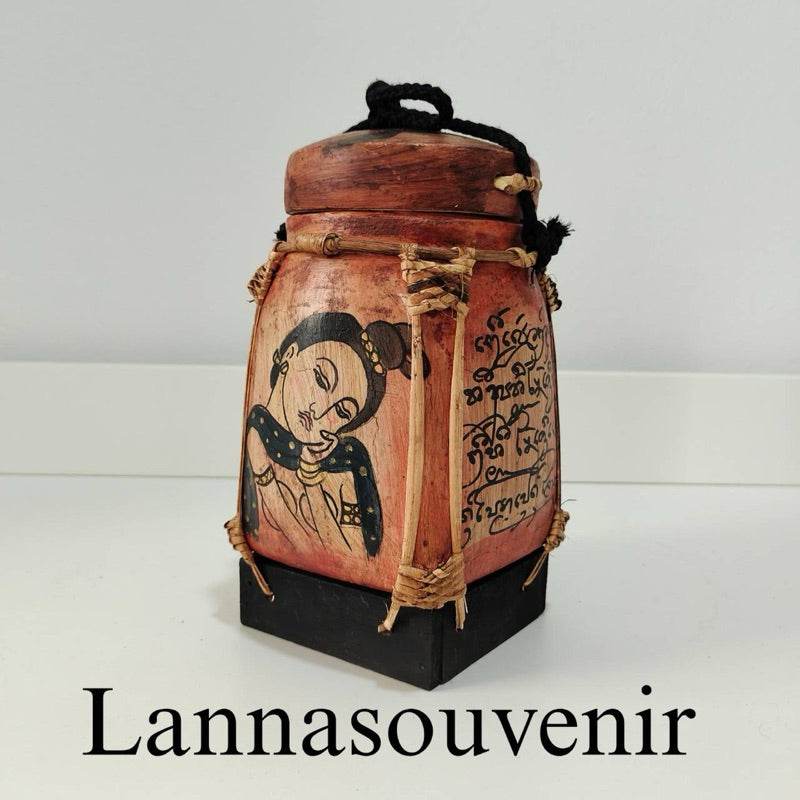 Lanna bamboo blessing box with traditional Thai artwork and calligraphy on a wooden base