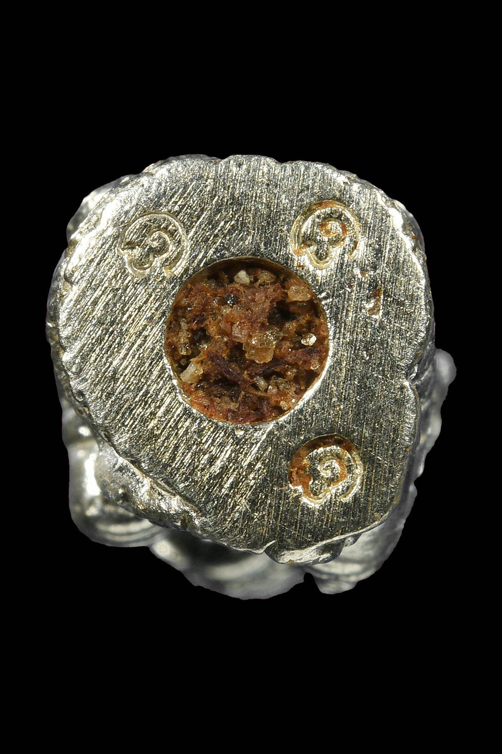 Lanna guardian wealth protection charm made of silver with intricate designs and a central garnet stone