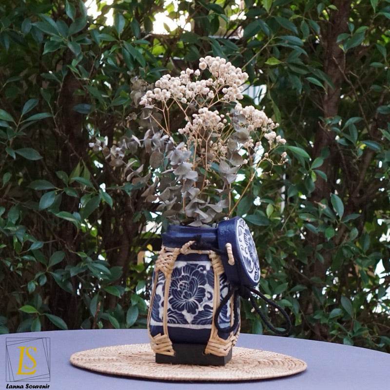 Handmade Thai rice basket styled as a decorative blue and white floral vase on a woven mat