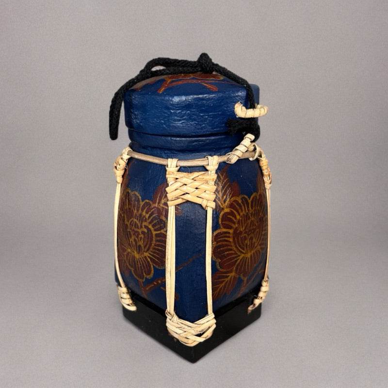 Handmade Thai rice basket with dark blue and brown floral design and woven rattan accents