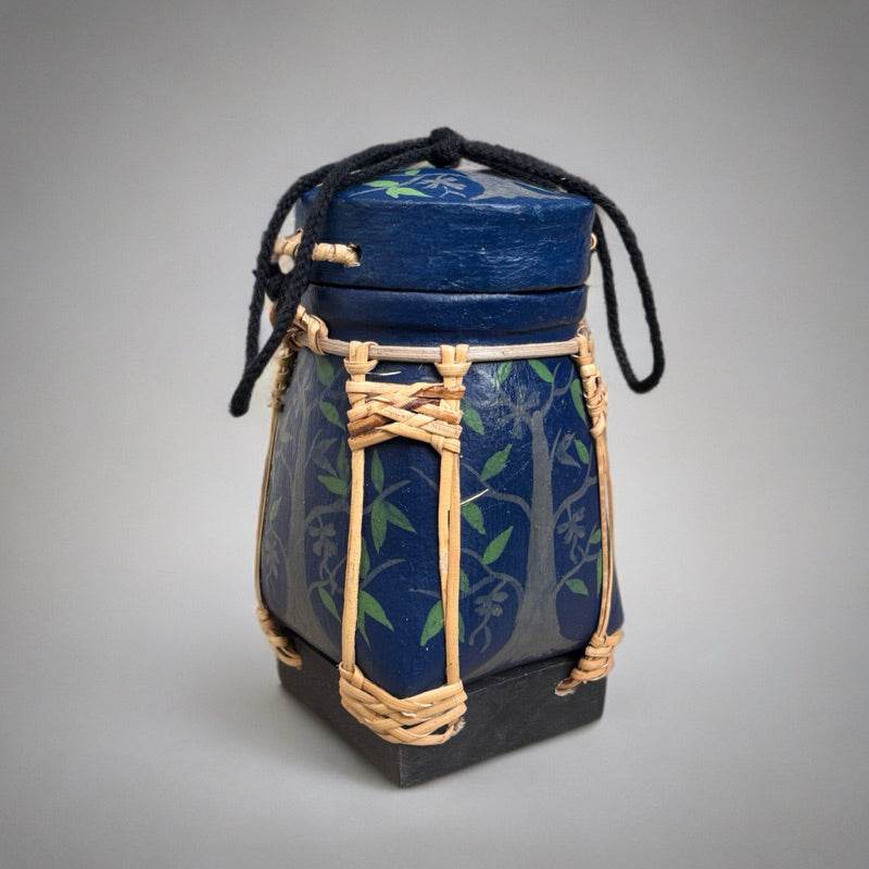Handmade Thai rice basket with blue decorative painting and natural woven rattan handle