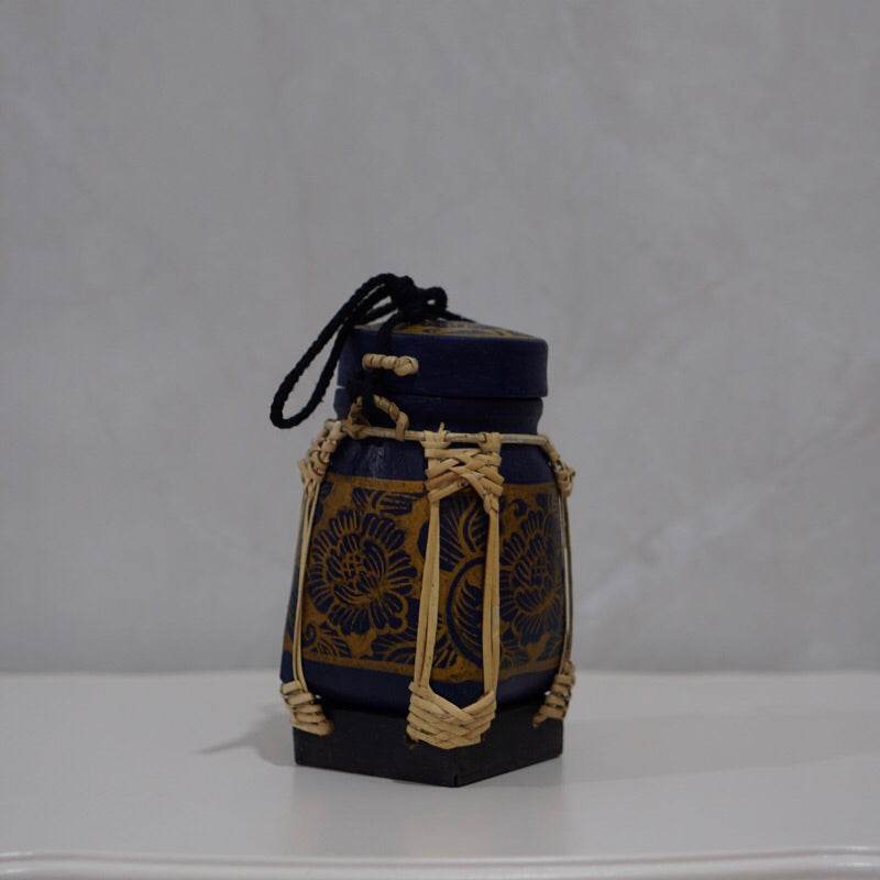 Handmade Thai rice basket with intricate floral patterns and woven natural fiber accents