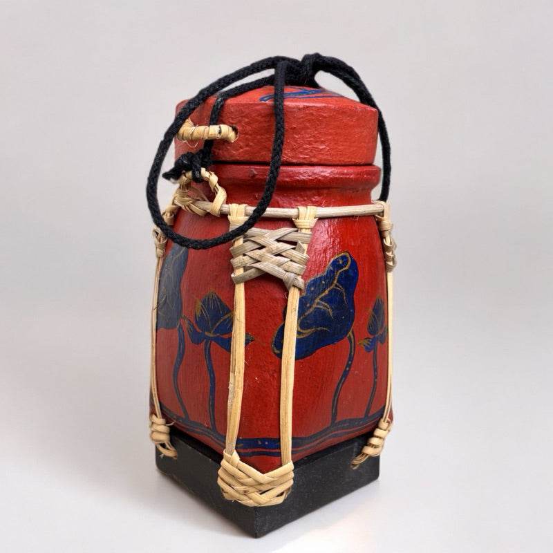 Handmade Thai rice basket with red and black paint and woven natural fiber details