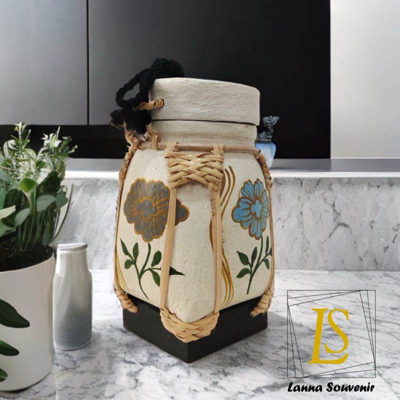 Handmade Thai rice basket with floral design and woven details on kitchen countertop