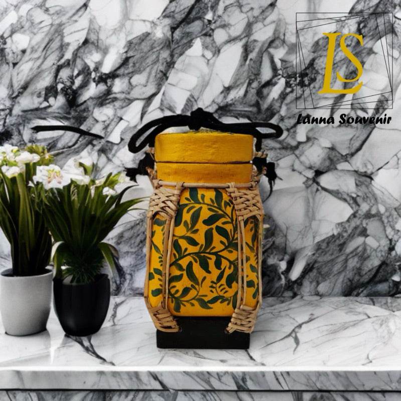 Handmade Thai rice basket with intricate leaf design and natural materials displayed on marble surface