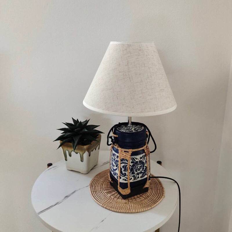 Handmade bamboo lamp for bedroom with white fabric shade and blue ceramic base on white round table