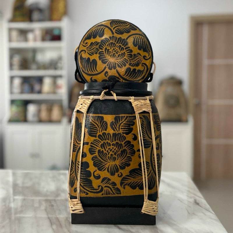 Lanna storage jar with floral pattern and woven details placed on a marble countertop in a kitchen