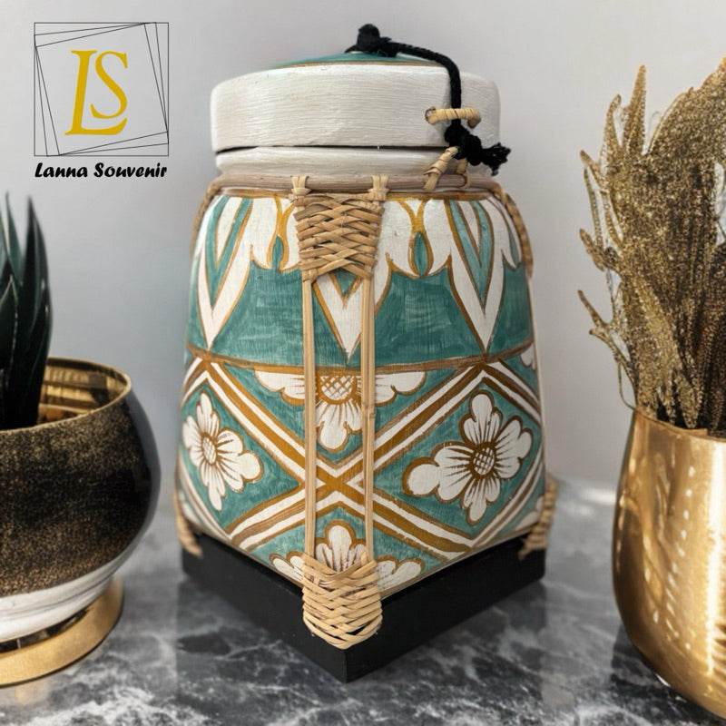 Lanna storage jar with floral pattern in green and white with woven details on a marble surface