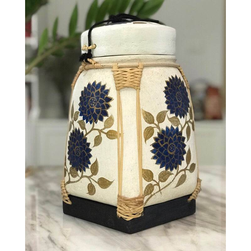 Lanna storage jar with floral pattern in blue and gold on white ceramic with woven accents
