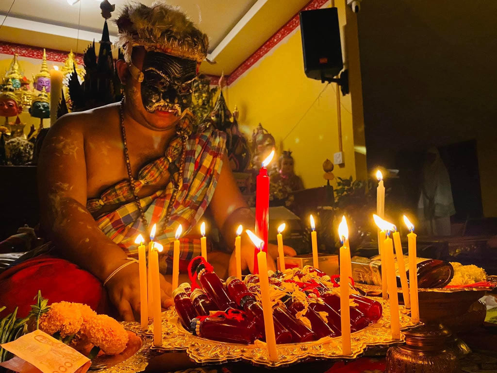 Lohit Sawat oil for attraction displayed on tray with candles and offerings during Thai ritual ceremony