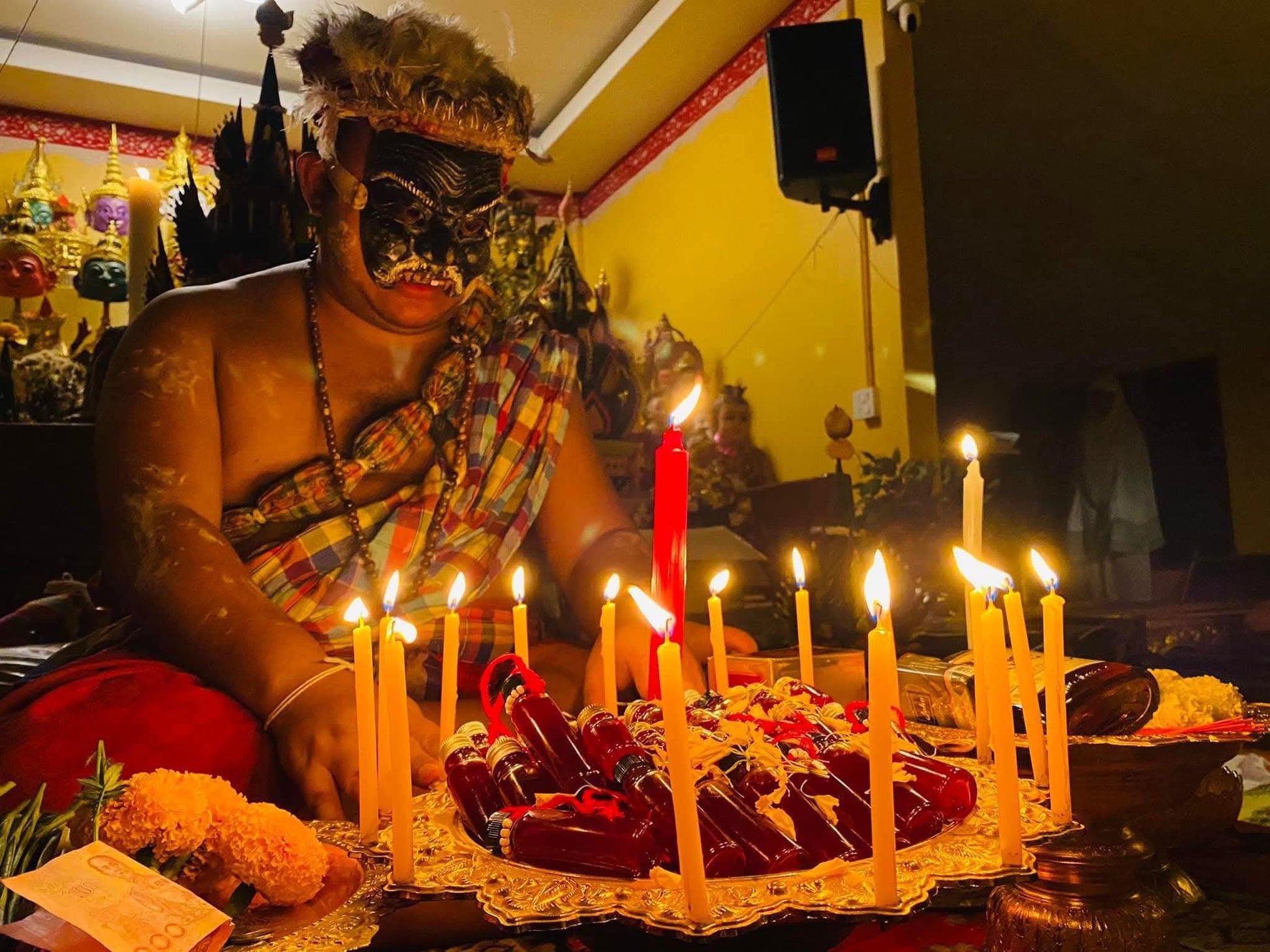 Lohit Sawat oil for attraction displayed on tray with candles and offerings during Thai ritual ceremony