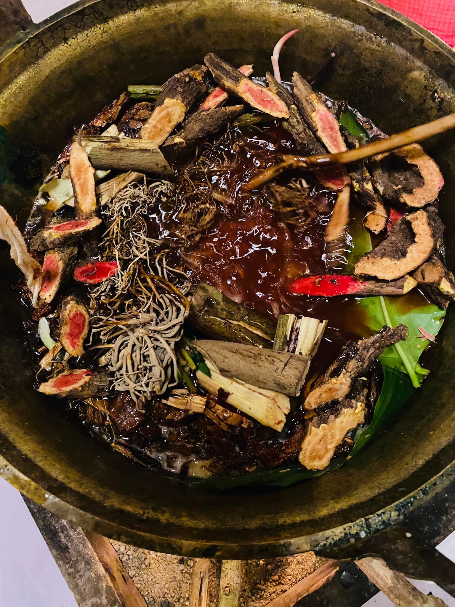 Thai Blessing Co ritual herb mixture simmering in brass pot with roots bark and resin Lohit Sawat oil for attraction