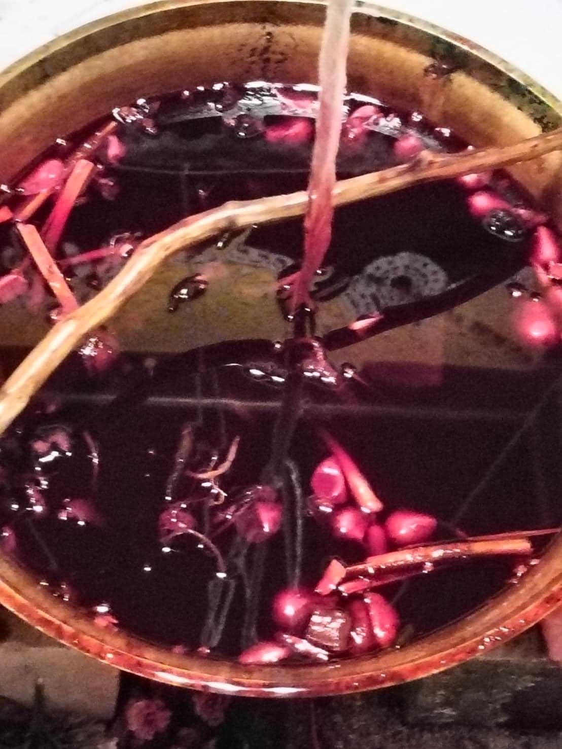 Lohit Sawat oil for attraction in a brass bowl showing dark red oil with herbs seeds and wooden twigs