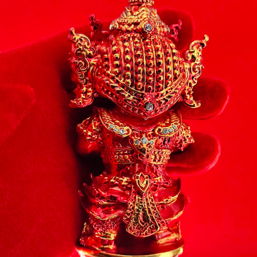Lord Vesuvanna lucky charm figurine in vibrant red with intricate details and sparkling accents