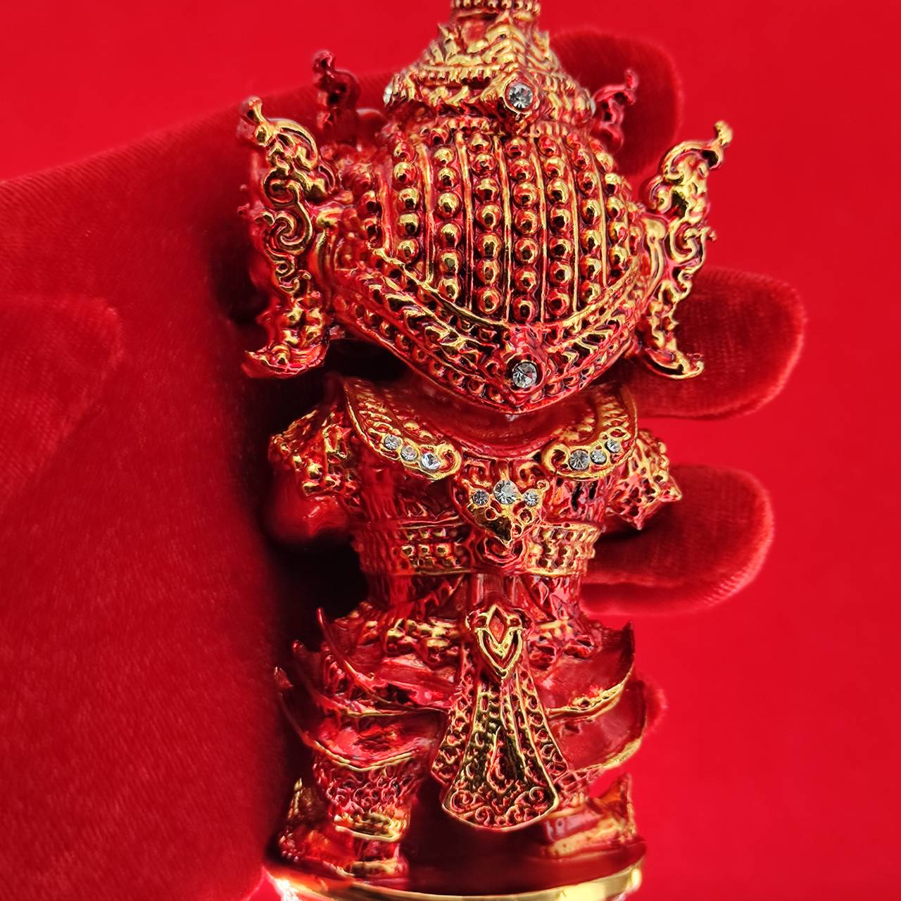 Lord Vesuvanna lucky charm figurine in vibrant red with intricate details and sparkling accents