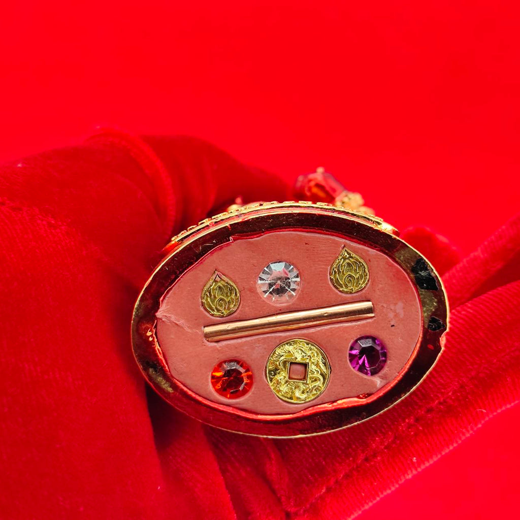 Lord Vesuvanna lucky charm figurine featuring vibrant gemstones and intricate details on a red background