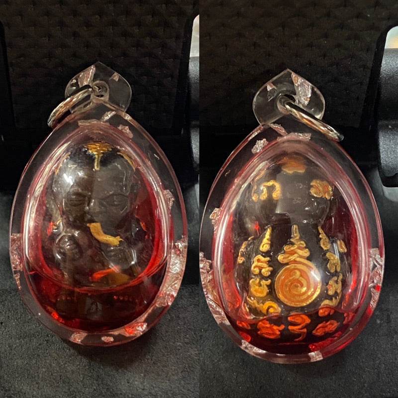 Guman Dood Rak black child amulet with gold script in red teardrop casing shown front and back