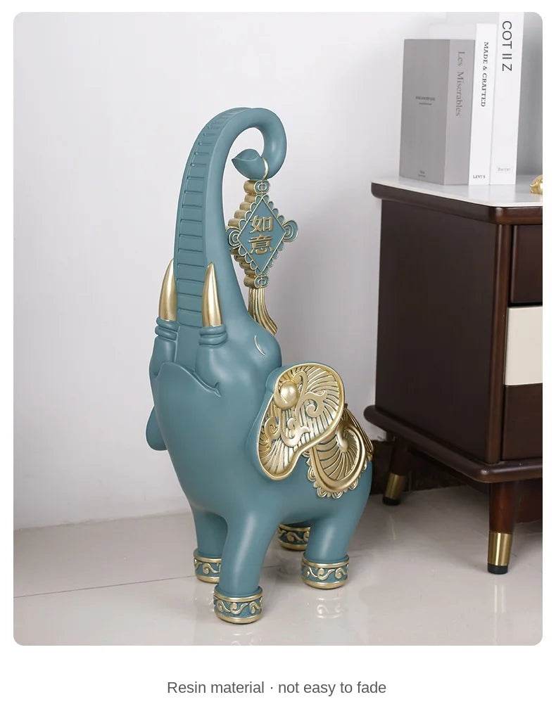 Teal resin decorative elephant with gold accents and curved trunk used as an elephant tray for keys and jewelry
