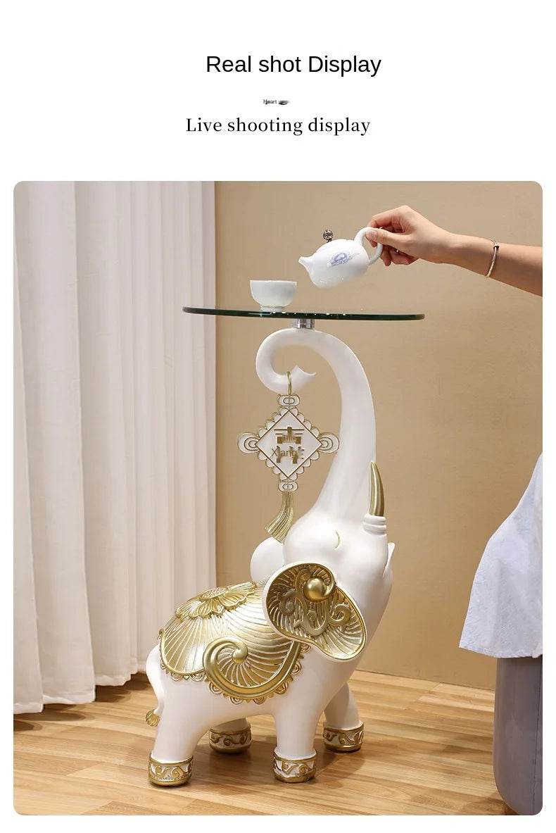 White decorative elephant tray for keys and jewelry with glass top and gold accents used as side table