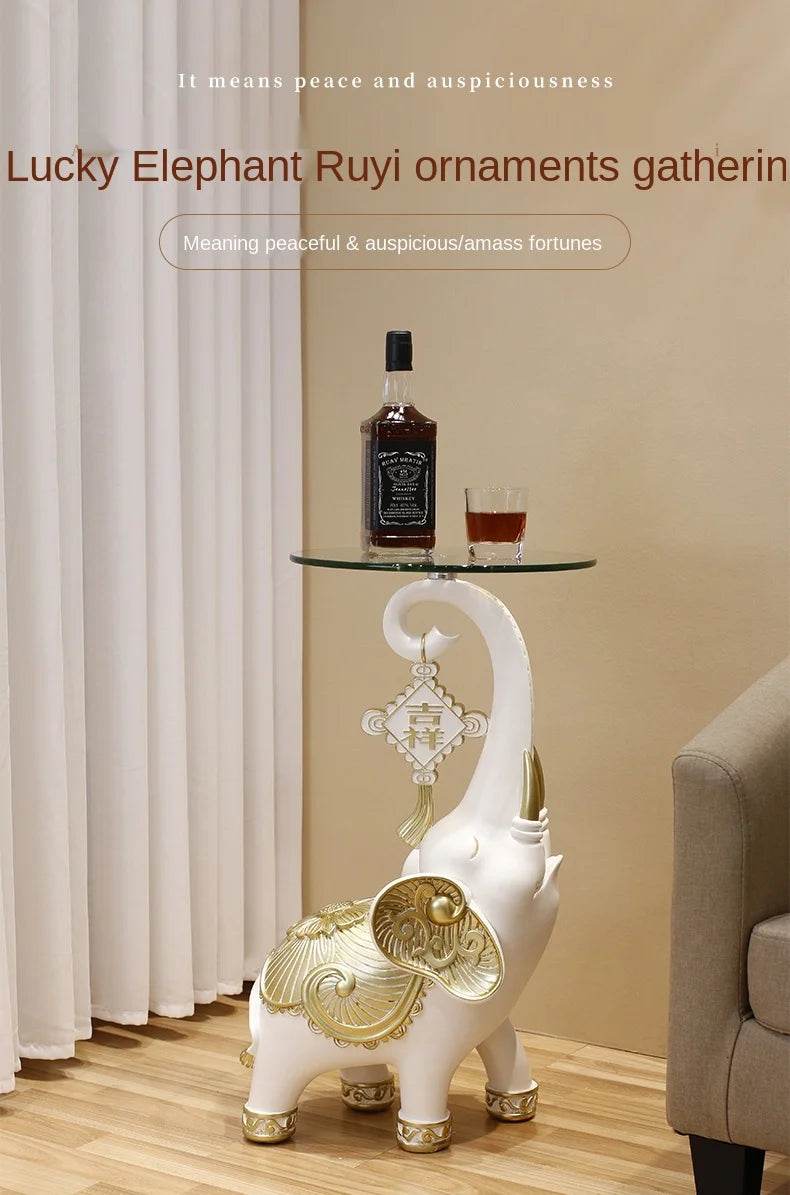 White ornamental elephant side table with gold accents and glass top used as elephant tray for keys and jewelry in living room