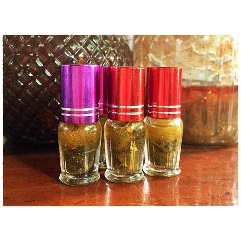Four bottles of Maha Phokasap oil for luck and wealth placed on a wooden surface for prosperity rituals